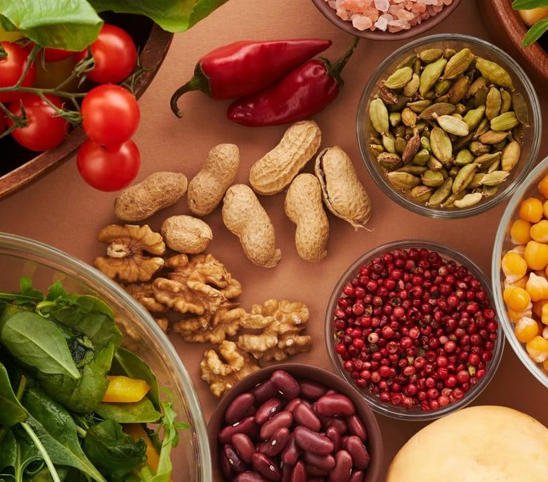Explore a colorful assortment of healthy ingredients, featuring vegetables, nuts, seeds, and spices in a top view layout.